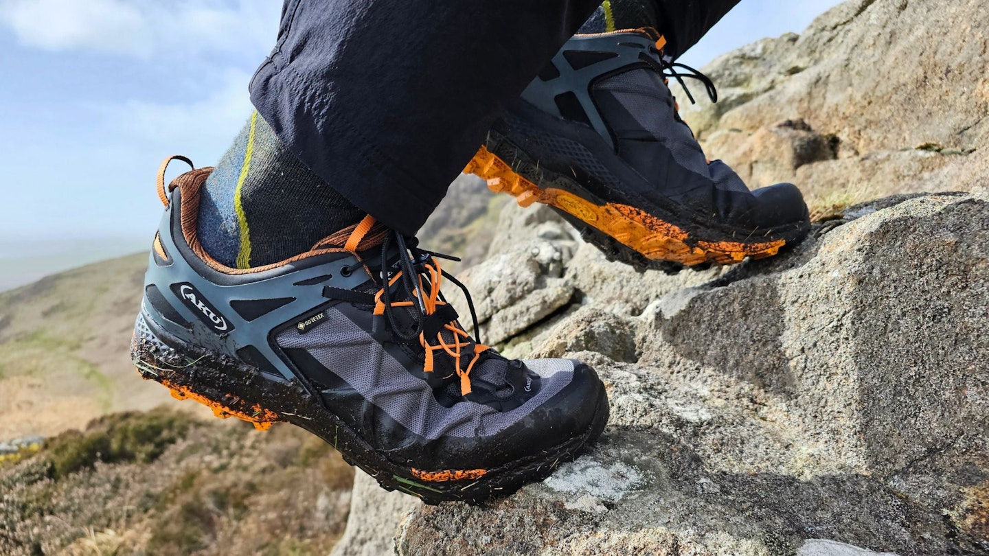 Closeup of hiker wearing AKU Rocket DFS GTX shoes, climbing a rock