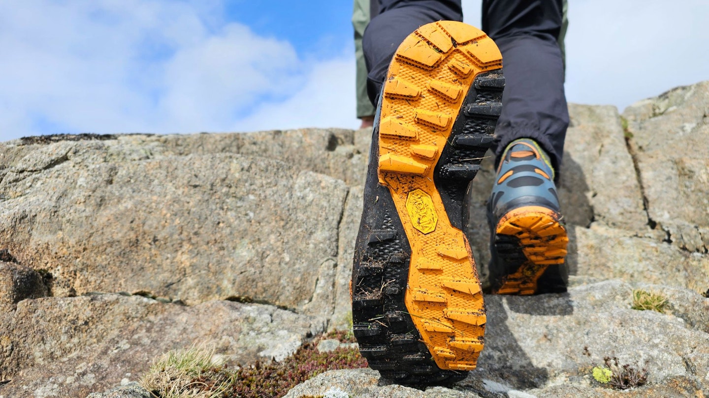 Hiker raising AKU Rocket DFS GTX to show outsole