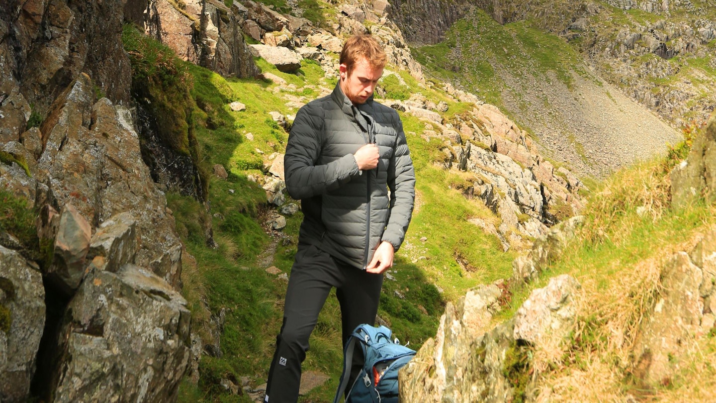 Hiker putting on Artilect Divide Fusion Stretch Jacket