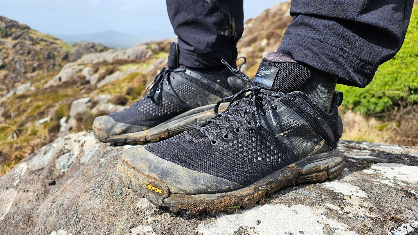 Closeup of hiker standing on a rock wearing Danner Trail 2650 GTX, left side view