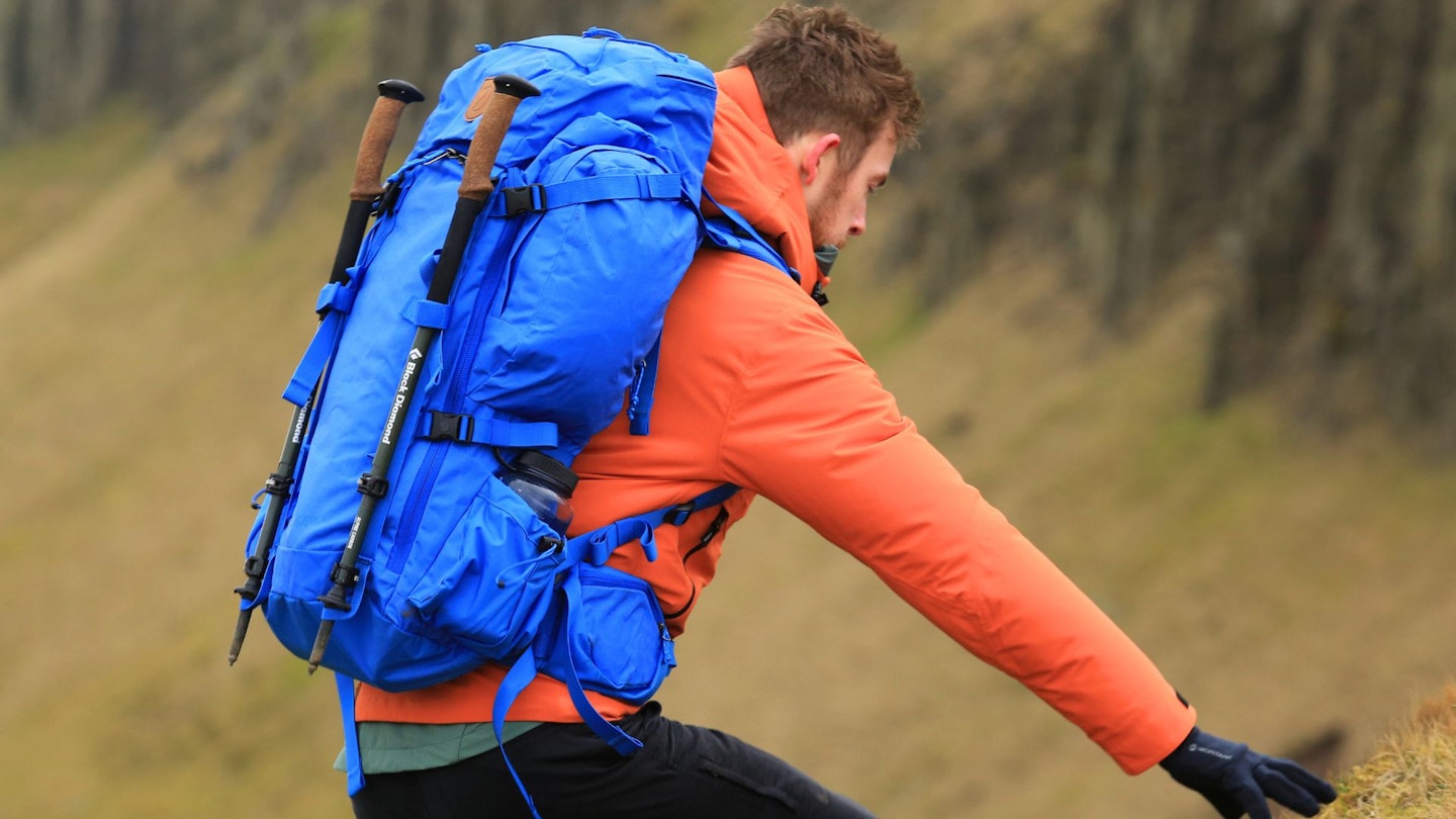 Chris Williams climbing a hill while testing the Fjällräven Kajka 55 in Cumbria