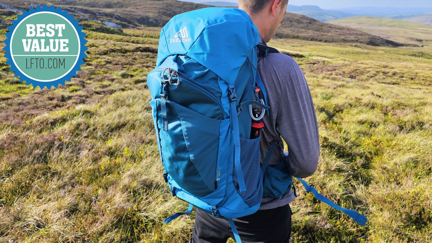 Hiker wearing Gregory Stout 55 with Best Value award logo