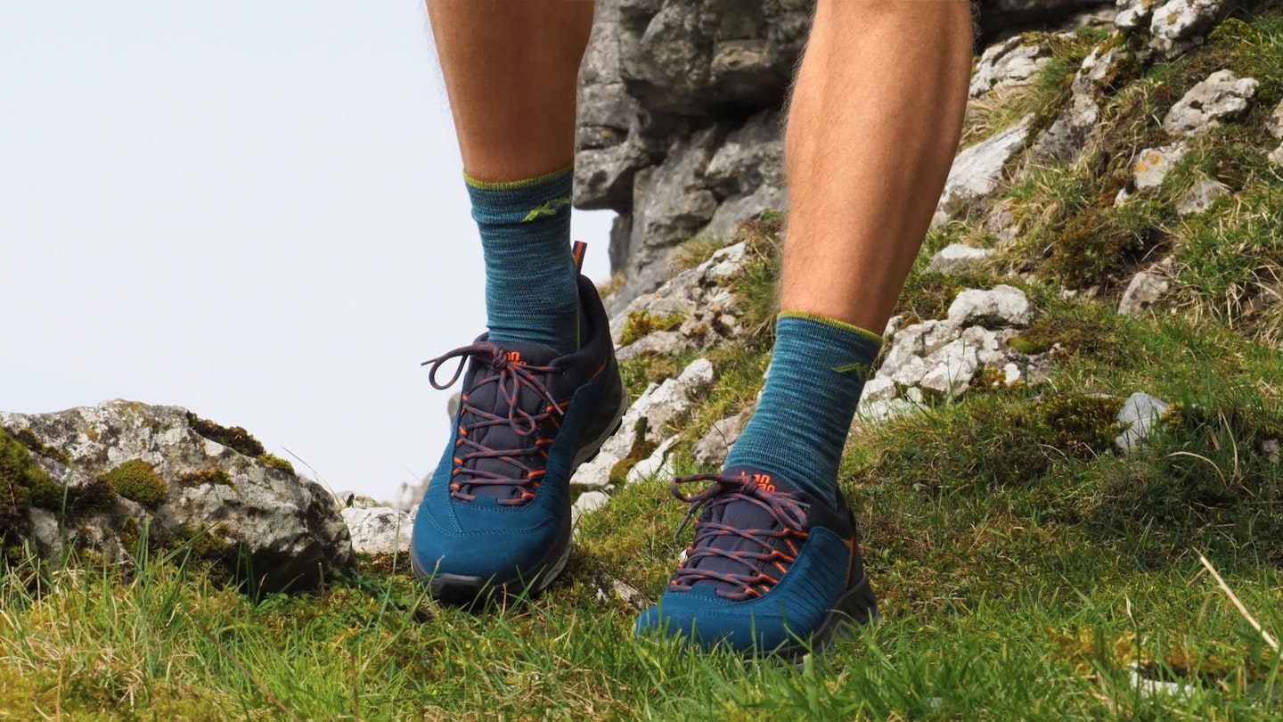 Closeup of a hiker wearing Hanwag Blueridge Low ES walking down a grassy slope