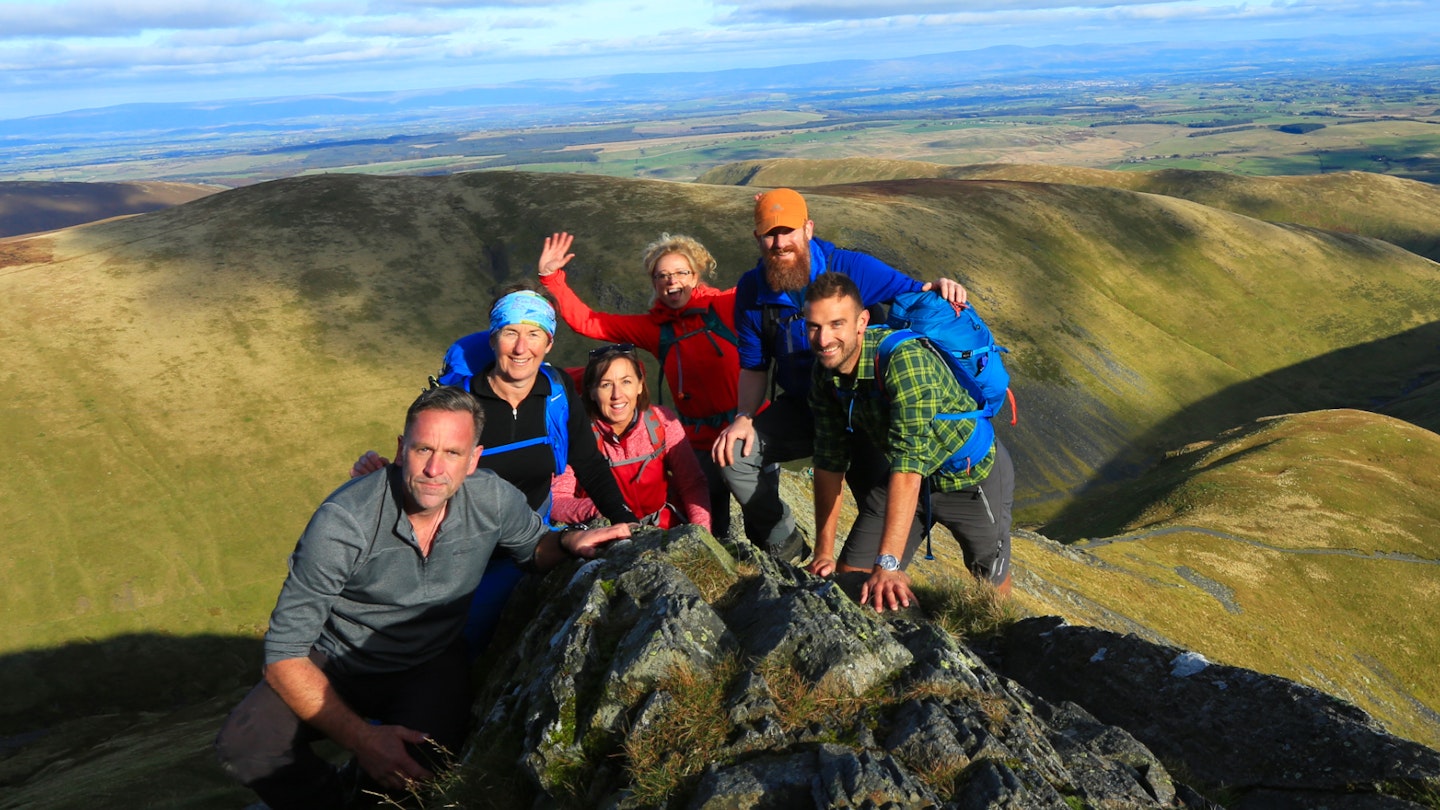 The Live For The Outdoors team together on a mountain ridge