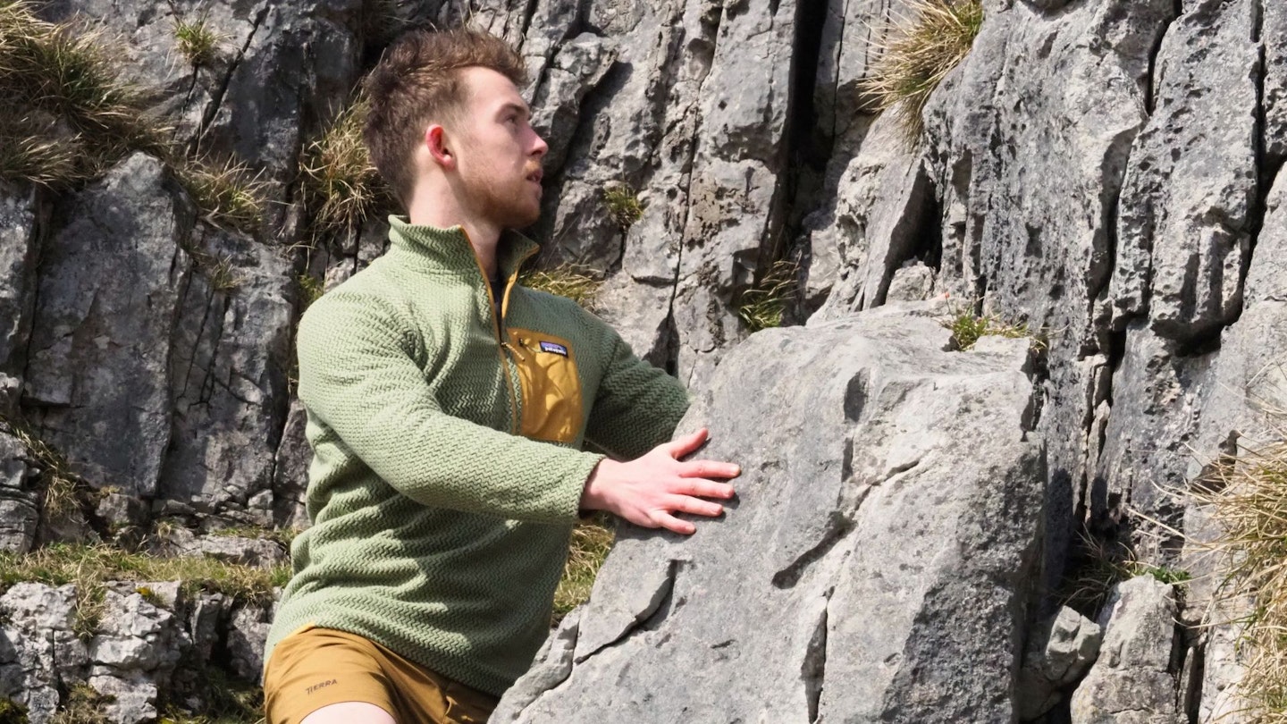 Hiker climbing wearing Patagonia R1 Air Zip Neck